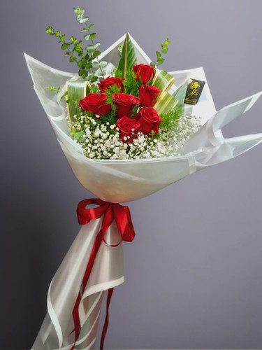 دسته گل رز قرمز ۷ شاخه لوکس با تزئینات مجلل، روبان ساتن و برگهای طلایی - تحویل سریع در ارومیه